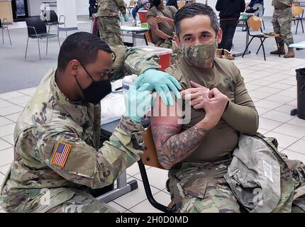 U.S. Army Command Sgt. Maj. Lonnie R. Null, Kommandofeldwebel-Major der 2d-Theatersignalbrigade, erhält seine erste Runde der COVID-19-Impfungen auf der USAG Wiesbaden, 27. Januar 2021. Das Verteidigungsministerium verteilt derzeit den Impfstoff COVID-19 in mehreren Phasen. Soldaten und andere Gemeindemitglieder werden ermutigt, über alle Ankündigungen ihrer lokalen Kliniken oder Befehlskette auf dem Laufenden zu bleiben, wenn der Impfstoff breiter verfügbar wird. Stockfoto