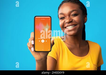 Musik-App Fröhliche Junge Schwarze Frau, Die Den Audioplayer Vorführt, Öffnete Sich Auf Dem Smartphone Stockfoto