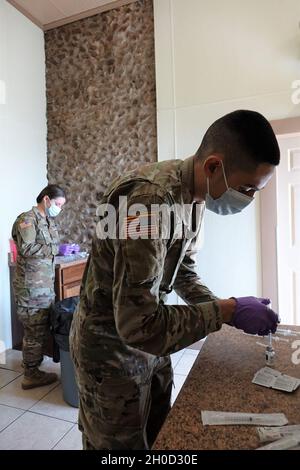 Sanitäter der Nationalgarde der Texas Army, Pvt. First Class Angela Holverson von der Joint Task Force Texas, bereitet ein Einsatzgebiet vor, um Spritzen mit Dosen des COVID-19-Impfstoffs zu füllen, 29. Januar 2021 in Cuero, Texas, Im Rahmen eines koordinierten Pilotprogramms des texanischen Department of Emergency Management (TDEM) wurde der Zugang zu Impfungen im gesamten ländlichen Texas verbessert. Zahlreiche Ärzte der texanischen Nationalgarde, alle national registrierten Notfallmediziner, arbeiten in mobilen Impfteams zur Unterstützung dieses Pilotprogramms. Stockfoto