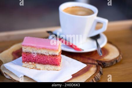 Scheibe Punch (Rum Tea) Kuchen mit Kaffee auf Holzbrett Stockfoto