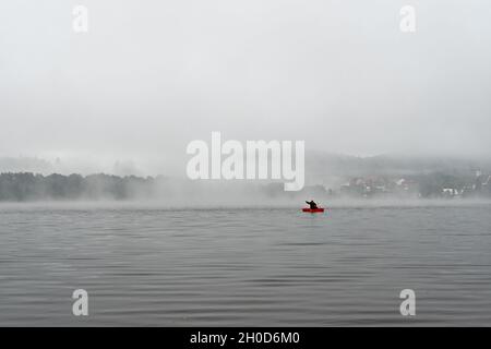 Fischer in einem Boot am frühen Morgen auf dem See Lipno in den Bergen Sumava, Tschechische Republik Stockfoto