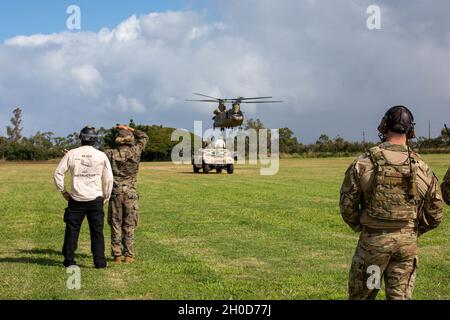 (Von links nach rechts) Mr. Jeffrey Ray, Sling Load Course Instructor, beobachtet U.S. Marine Corps CPL. Adrian Asencio signalisiert dem Hubschrauber, sich über ein Fahrzeug zu bewegen, während Pete Esparza, Senior Airman der US-Luftwaffe, Mitglied der Tactical Air Control Party, 25th Air Support Operations Squadron, Überwacht und kommuniziert mit dem Flugzeug während des Hands-on-Teils des Schleuderbeladungskurses in Area X auf Schofield Barracks, Hawaii, am 29. Januar 2020. Das Training wurde von der 25. Division Sustainment Brigade, 25. Infanterie Division durchgeführt und sowohl Marines als auch S zertifiziert Stockfoto