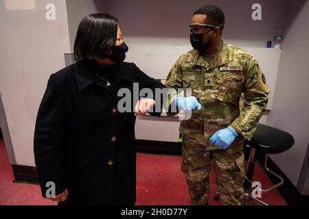 Col. Lisa J. Hou, D.O., links, Interim Adjutant General, stößt Ellbogen mit SPC. Nichola A. Baldie, 44. Kampfteam der Infanterie-Brigade, Nationalgarde der New Jersey Army, auf dem neu eröffneten COVID-19-Impfplatz von Bergen County in East Rutherford, N.J., 29. Januar 2021. Die Bürger-Soldaten unterstützen Gesundheitshelfer bei der Temperaturkontrolle, geben Versicherungsinformationen ein, führen Einzelpersonen durch die verschiedenen Stationen und überwachen Menschen, nachdem sie ihre Impfungen erhalten haben. (New Jersey Stockfoto