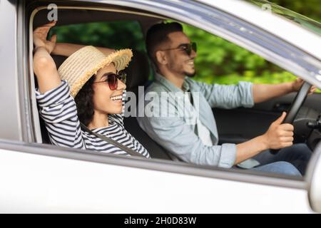 Glückliches arabisches Paar, das am Wochenende im Sommer mit dem Auto unterwegs war Stockfoto