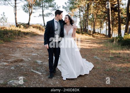 Der Ehemann legte seinen Arm über die Schulter seiner Frau, während er durch den Wald ging Stockfoto