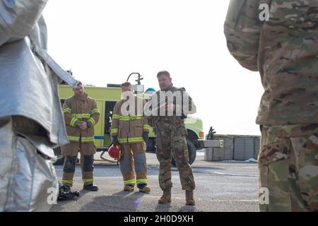 Chief Warrant Officer 3 Lee Fuller, Flugsicherheitsbeauftragter des Regionalkommandos Ost, Kosovo-Streitkräfte, spricht mit der Feuerwehr des Lagers Bondsteel nach einer Vorprobe des Unfallplans am Lufttankpunkt des Lagers Bondsteel am 29. Januar 2021. Flugpersonal, Militärpolizei, Flüchtlinge und die CBFD reagierten auf einen simulierten Flugzeugnotfall mit einem UH-60 Blackhawk. Der Vorwärtsarm und der Tankpunkt, an dem die Probe durchgeführt wurde, gehören zu den Bereichen, in denen die Mitglieder der Flugcrew das größte Risiko eingehen. Regelmäßiges Training reduziert dieses Risiko, minimiert Geräteschäden und spart Liv Stockfoto