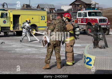 Chief Warrant Officer 3 Lee Fuller, Flugsicherheitsbeauftragter des Regionalkommandos Ost, Kosovo Force, arbeitet mit der Lagerfeuerwehr Bondsteel während einer Vorprobe des Flugbetankungspunkts Camp Bondsteel am 29. Januar 2021 zusammen. Flugpersonal, Militärpolizei, Flüchtlinge und die CBFD reagierten auf einen simulierten Flugzeugnotfall mit einem UH-60 Blackhawk. Der Vorwärtsarm und der Tankpunkt, an dem die Probe durchgeführt wurde, gehören zu den Bereichen, in denen die Mitglieder der Flugcrew das größte Risiko eingehen. Regelmäßiges Training reduziert dieses Risiko, minimiert Geräteschäden und rettet Leben. Stockfoto