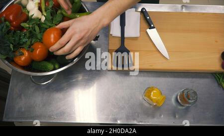Frisches Rohes Frühlingsgemüse. Clip. Essen Vegetarisch Hintergrund. Tomaten, Gurke, Radieschen, Salatblätter im Metallkorb. Draufsicht Stockfoto