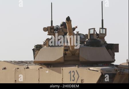 Ein Soldat der US-Armee vom 1. Bataillon, 6. Infanterie-Regiment, leitet einen benachbarten Panzer in das Gebiet, in dem sich der M1 Abrams-Panzer befindet, der während einer Situationstraining-Übung am 30. Januar 2021 für die Iron Union 14 auf dem Al Hamra Military Airfield in den Vereinigten Arabischen Emiraten bewegt. Die Iron Union ist eine wiederkehrende Übung, die die Partnerkapazität erweitert und die Ziele der Sicherheitszusammenarbeit im Nahen Osten und Südwestasien unterstützt. Stockfoto