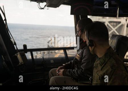 Der erste LT. Kazuhige Mori, ein Pilot-Offizier der 105. Aviation Unit, arbeitet mit dem US Navy LT. Tim McNerney, einem stellvertretenden Luftoffizier des amphibischen Sturmschiffs USS America (LHA 6), während ein JGSDF CH-47 mit 1. Hubschrauber-Brigade, Western Army Aviation Group, Führt an Bord der LHA 6 in der philippinischen See Berührungs- und Go-Übungen durch, 31. Januar 2021. Durch Schulungen mit dem JGSDF verbessert die 31. Marine Expeditionary Unit (MEU) die Interoperabilität und die Fähigkeit, sich mit einem wichtigen Verbündeten zu integrieren. Die 31. MEU ist an Bord von Schiffen der America Expeditionary Str Stockfoto