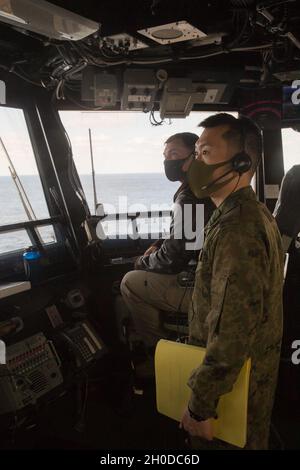 Der erste LT. Kazuhige Mori, ein Pilot-Offizier der 105. Aviation Unit, arbeitet mit dem US Navy LT. Tim McNerney, einem stellvertretenden Luftoffizier des amphibischen Sturmschiffs USS America (LHA 6), während ein JGSDF CH-47 mit 1. Hubschrauber-Brigade, Western Army Aviation Group, Führt an Bord der LHA 6 in der philippinischen See Berührungs- und Go-Übungen durch, 31. Januar 2021. Durch Schulungen mit dem JGSDF verbessert die 31. Marine Expeditionary Unit (MEU) die Interoperabilität und die Fähigkeit, sich mit einem wichtigen Verbündeten zu integrieren. Die 31. MEU ist an Bord von Schiffen der America Expeditionary Str Stockfoto