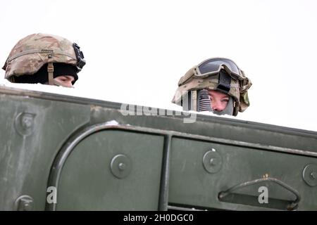 US-Soldaten der 1. Staffel, 2d-Kavallerie-Regiment, verstärkte Vorwärtspräsenz der Battle Group Poland, blicken über die Spitze eines strykers, bevor sie am 2. Februar 2021 im Bemowo Pikie Training Area, Polen, eine gemeinsame Live-Feuerübung mit den Siebenbürgischen Geparden der rumänischen Armee absolvieren. Stockfoto