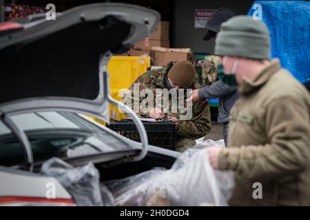 Spc. Bradley Crevling, Ein Unternehmen, 181st Brigade Support Bataillon, lädt ein Lieferwagen des Fahrers, während SPC. Yaquelin Gutierrez, 506th Military Police Detachment, 96. Truppenkommando, nimmt den Befehl ab, 2. Februar 2021, Kent Wash. Crevling und Gutierrez sind Einheimische aus Washington, die aktiviert wurden, um risikoreichen Gemeinden bei der Bekämpfung der Hungerkrise zu helfen, die durch COVID-19 verursacht wurde. Stockfoto