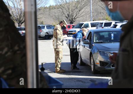 Sgt. Kyle Cramer, ein Kampfingenieur, der dem 236th Brigade Engineer Bataillon, dem 30th Armored Brigade Combat Team und Ruthie Capaforte, einer Krankenschwester des Macon County Public Health Department, zugewiesen wurde, untersuchen eine Patientin, bevor sie am 9. Februar 2021 in Franklin, North Carolina, ihre COVID-19-Impfung erhielt. Soldaten der North Carolina National Guard und Luftwaffe werden im ganzen Staat aktiviert, um die lokalen Gesundheitsbehörden bei der Steigerung der Effizienz der Impfstoffverabreichung zu unterstützen. Stockfoto