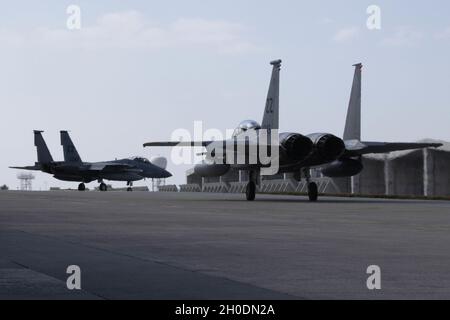 Zwei US-Luftstreitkräfte-Kampfflugzeuge vom 44. Jagdgeschwader nehmen F-15C Eagles mit dem Taxi, um vom Kadena Air Base, Japan, am 4. Februar 2021 nach Cope North 21 zu starten. Cope North 21 ist eine trilaterale Trainingsübung zwischen US-, japanischen und australischen Luftstreitkräften, um Kampffähigkeiten zu entwickeln und die Luftüberlegenheit, elektronische Kriegsführung, Luftverbot, taktische Luftbrücke und Luftbetankung zu verbessern. Stockfoto