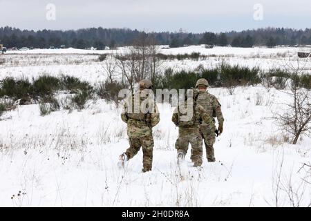 US-Soldaten der 1. Staffel, 2D-Kavallerie-Regiment verlassen eine schneebedeckte Strecke, nachdem sie die Truppen der kroatischen Armee vom 17. Kontingent, Volcano Battery, verstärkte Vorwärtspräsenz beobachtet haben Battle Group Poland demonstrieren ihre Kompetenz mit Artillerieraketen bei einem Live-Feuerereignis am 4. Februar 2021 im Bemowo Pikie Training Area, Polen. Stockfoto