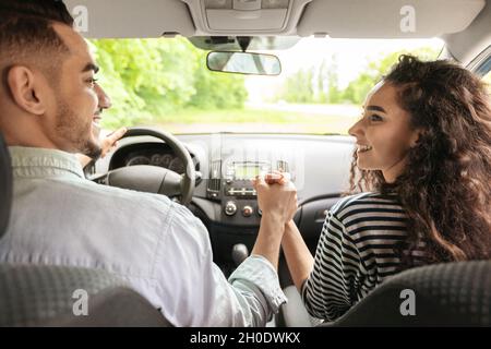 Liebevolles Paar, das die Hände hält, während es im Auto sitzt, Rückansicht Stockfoto