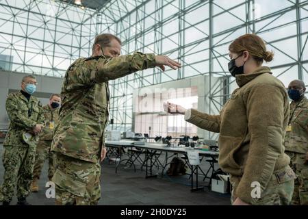 New Yorker Wache Brig. General David Warager, Kommandant der staatlichen Verteidigungskräfte der New Yorker Garde, besucht Freiwillige, die mit dem Kommandoposten der New Yorker Nationalgarde im Javits Convention Center in Manhattan, New York, am 05. Februar 2021, arbeiten. SPC der US-Armee. Janessa Walker, eine für die ordnungsgemäße Verladung und Bewegung von Fracht verantwortliche Kraftfahrzeugbetreiberin, die der 719. Composite Truck Company, 369. Sustainment Brigade, 53. Truppenkommando, zugewiesen wurde, erhält eine Sondermünze von Brig. General David Warager für Walkers außergewöhnliche Arbeit, die Operationen zur Unterstützung von Mass COVID-19 va durchführt Stockfoto