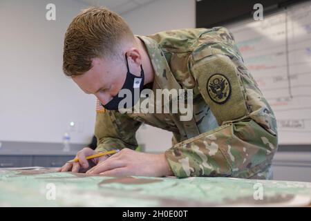 US Army Sgt. Landon Smith, ein Konkurrent des 42. Zivilunterstützungsteams, zeichnet Punkte auf einer Karte während eines 60. Truppenkommandos (60. TC) Best Warrior Competition auf, der vom 5. Bis 7. Februar 2021 im Claude T. Bowers Military Center in Raleigh, North Carolina, stattfand. Der BWC des 60. TC fordert Soldaten auf, sich mit militärischen Operationen, grundlegenden Kriegeraufgaben und körperlicher Fitness zu kennen. (North Carolina Army Stockfoto