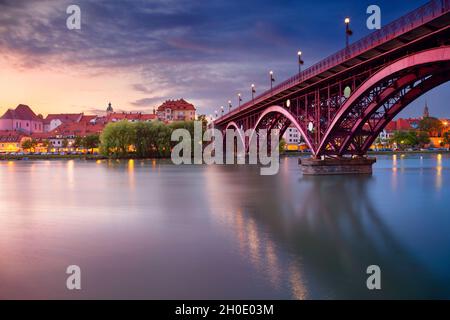 Maribor, Slowenien. Stadtbild von Maribor, Slowenien bei schönem Sommeruntergang mit Spiegelung der Stadt in der Drau. Stockfoto