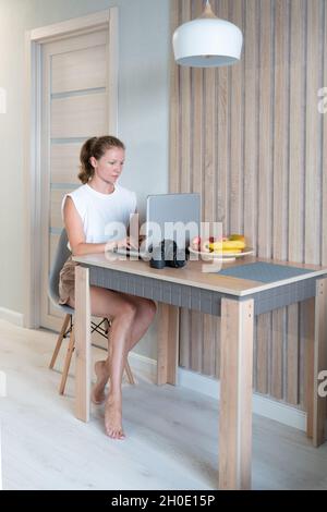 Frau mit Laptop zu Hause Stockfoto