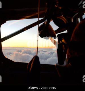 Die Sonne geht auf den Wolken vor dem Cockpitfenster eines KC-135 Stratotankers mit dem 434th Air Betanking Wing von der Grissom Air Reserve Base, Indiana, am 8. Februar 2021 unter. Der Stratotanker wurde an die 927. ARW, Florida, verliehen, aus der die Piloten und der Boombetreiber kamen. Stockfoto