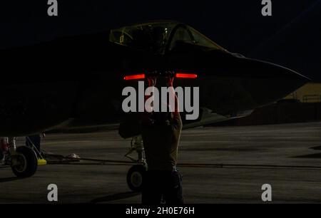 Senior Airman Vincent Diaz, taktischer Flugzeugbetreuer, der dem 34. Jagdflugzeug der Generation Squadron auf der Hill Air Force Base, Utah, zugewiesen wurde, meldet während der Red Flag 21 einen F-35A Lightning II-Kampfjet-Piloten auf der Nellis AFB, Nevada, 8. Februar 2021. Diaz koordinierte sich mit dem Piloten, um sicherzustellen, dass die Flugzeugsysteme vor ihrer Mission mit der Roten Flagge funktionierten. Stockfoto