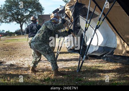 GULFPORT, Mississippi (Feb 8, 2021) – Seebeer, die dem mobilen Baubataillon 1 der Marine (NMCB) zugewiesen sind, bauen ein Zeltlager für die Impfstoffverwaltung COVID-19 im Marinebataillon-Zentrum Gulfport, Mississippi, 8. Februar 2021. Die geplante Fähigkeit des Lagers besteht darin, 250 COVID-19-Impfstoffe pro Tag bereitzustellen. NMCB 1 führt einen rigorosen Trainingsplan für den Heimsport durch, um Baumaßnahmen, humanitäre Hilfe und Sicherheitsoperationen durchzuführen. Stockfoto