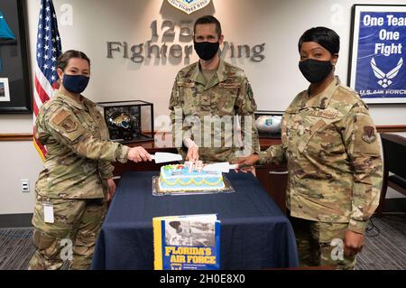 Von links nach rechts: US Air Force Airman 1st Class Lacy Ashcroft, Col. Matthew French und Command Chief Master Sgt. Angella Beckom, Pose vor dem Schneiden eines Kuchens zur Feier des 125. Fighter Wing Geburtstag, 9. Februar 2021. Stockfoto