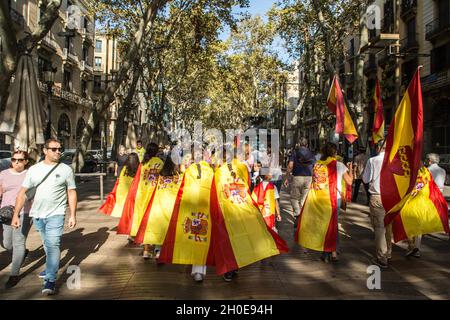 Barcelona, Spanien. Oktober 2021. Am Hispanic Day auf der Rambla in Barcelona werden Menschen mit spanischen Flaggen gesehen.Menschen haben an der Blumengabe zur Statue von Christoph Kolumbus in Barcelona anlässlich des 12. Oktober, dem Hispanic Day, der von der rechtsextremen Partei VOX organisiert wurde, teilgenommen. Es gab den VOX-Sprecher im katalanischen Parlament, Ignacio Garriga, begleitet von den beiden Sprechern der katalanischen Kammer, Juan Garriga und Antonio Gallego, sowie dem Abgeordneten Andres Bello. Kredit: SOPA Images Limited/Alamy Live Nachrichten Stockfoto