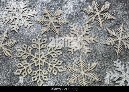 Weihnachten und Neujahr verschneiten Hintergrund. Schneeflocken weiß silber und Gold Farbe flach legen. Winterferien Schneefall, Stockfoto