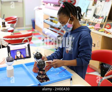 Amiyah Davis, 8, kleidet eine japanische „Hinamatsuri“-Puppe während einer virtuellen Handwerksklasse im School Age Center, Sagamihara Family Housing Area, Japan, 9. Februar. Stockfoto