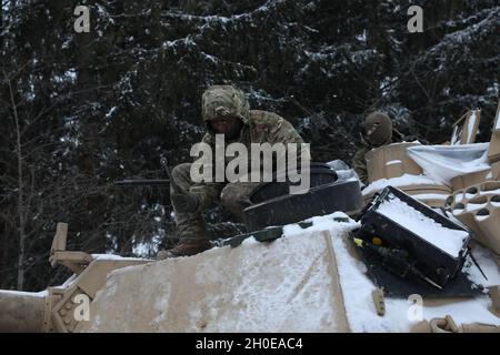 Ein US-Soldat, der dem 1. Squadron, dem 7. Kavallerieregiment, zugewiesen ist, führt vorbeugende Wartungskontrollen und -Dienste an seinem gepanzerten Fahrzeug durch, um eine Live-Feuerübung im Trainingsgebiet Grafenwoehr, Grafenwoehr, Deutschland, 9. Februar 2021, vorzubereiten. Combined Resolve XV ist eine vom Hauptquartier der Armee geleitete multinationale Übung, die zum Aufbau des Kampfteams der 1. Panzerbrigade, der Bereitschaft der 1. Kalvariendivision und zur Verbesserung der Interoperabilität mit verbündeten Kräften entwickelt wurde, um gegen jeden Gegner zu kämpfen und zu gewinnen. Stockfoto