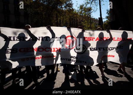 Esp. Oktober 2021. Menschen, die ein Transparent mit der Aufschrift „Hispanicity ist Völkermord“ halten, marschieren während der Demonstrationen zum Nationalfeiertag Spaniens, der auch als Hispanic Day oder Tag der Hispanicity am 12. Oktober 2021 in Barcelona, Spanien, bekannt ist. Das Fest erinnert an die Ankunft Kolumbus in Amerika und ist umstritten geworden, da es als ein Fest des Kolonialismus wahrgenommen wird. (Foto von Davide Bonaldo/Sipa USA) Quelle: SIPA USA/Alamy Live News Stockfoto