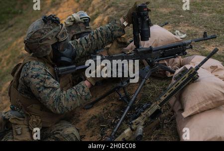 U.S. Marine Corps Lance CPL. Christopher Jaco (links) und Lance CPL. Shawn Marr (rechts), beide Maschinengewehrschützen bei India Company, 3d Bataillon, 8th Marine Regiment, laden während eines Live-Feuers auf Camp Hansen, Okinawa, Japan, 10. Februar 2021 ein M240B Maschinengewehr neu. Die Marines unterstützten ein Angriffselement per Feuer und demonstrierten damit ihre Fähigkeiten in der Infanterie und der kombinierten Rüstungstaktik. 3/8 ist derzeit im Rahmen des Unit Deployment Program an die 3d Marine Division angeschlossen. Jaco stammt aus Jacksonville, North Carolina, und Marr stammt aus Uniondale, New York. Stockfoto