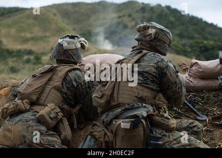 U.S. Marine Corps Lance CPL. Christopher Jaco (rechts) und Lance CPL. Shawn Marr (links), beide Maschinengewehrschützen bei India Company, 3d Battalion, 8th Marine Regiment, bedienen während eines Live-Feuers auf Camp Hansen, Okinawa, Japan, 10. Februar 2021, ein M240B Maschinengewehr. Die Marines unterstützten ein Angriffselement per Feuer und demonstrierten damit ihre Fähigkeiten in der Infanterie und der kombinierten Rüstungstaktik. 3/8 ist derzeit im Rahmen des Unit Deployment Program an die 3d Marine Division angeschlossen. Jaco stammt aus Jacksonville, North Carolina, und Marr stammt aus Uniondale, New York. Stockfoto