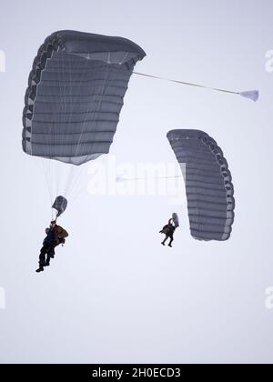 Die Paraskette der Alaska Air National Guard von 212. Rettungsgeschwader steigt nach einem Ausgang von einer 210. Rettungsgeschwader HH-60G Pave Hawk am 10. Februar 2021 in der Malamute Drop Zone der Joint Base Elmendorf-Richardson ab. Der Sprung ging der Befehlswechselzeremonie für die 212. RQS voraus. Stockfoto