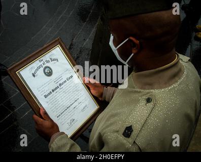 U.S. Marine Corps Sgt. Maj. Christopher Thomas, der Major der Rekrutierungsstation Harrisburg Pennsylvania, liest den Beförderungsbefehl für den Warrant Officer Eric Newman während seiner Ernennungszeremonie an Bord der Marine Corps Base Quantico am 11. Februar 2021. Newman wurde von seiner Tochter, seinem Rekrutierer Master Gunnery Sgt, an seinen derzeitigen Rang festgeklemmt. Nichola Tyciak III, der Recruiter-Ausbilder der Recruiting Station Columbus Ohio, und sein Recruit Training Senior Drill Instructor Sgt. Maj. Christopher Thomas. Nach Abschluss des Grundkurses für den Offiziersbefehl und der Grundschule wird Newman die Stockfoto