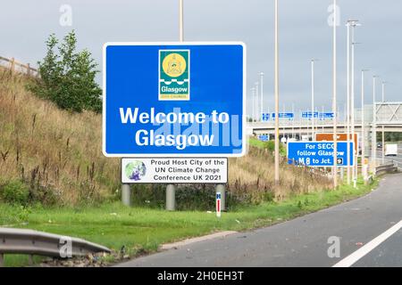 Glasgow, Schottland, Großbritannien. Oktober 2021. Willkommen in Glasgow "Proud Host City of the UN Climate Change Conference UK 2021" Schild neben der Autobahn M8, als die COP26 Coalition einen Aufruf des Human Hotel an die Einwohner von Glasgow teilte, Gastgeberinnen in Gastfamilien zu werden und Mitkämpfern für den Klimaschutz in Glasgow zu helfen.Quelle: Kay Roxby/Alamy Live News Stockfoto