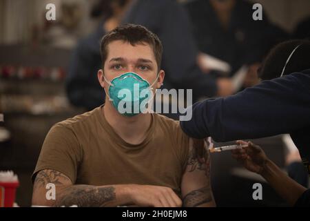 210213-N-WQ732-3001 NORFOLK, Virginia (Feb 13, 2021) – Gas Turbine Systems Technician (Electrical) Petty Officer 2nd Class Jacob Wilson aus Walhalla, South Carolina, erhält den COVID-19-Impfstoff an Bord des Lenkraketen-Kreuzers USS Monterey (CG 61) der Ticonderoga-Klasse (CG 13. Februar 2021). Monterey befindet sich derzeit an der Pier-Seite der Naval Station Norfolk, die Routinewartung durchführt. Stockfoto