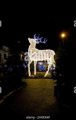 Weihnachtsinstallation in Form eines Rentiers, verwischt mit scharfem Filmkorn und defokussierten Effekt, um das Foto antiquiert wirken zu lassen Stockfoto