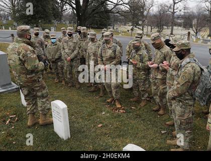 US-Soldaten mit dem Kampfteam der 27. Infanterie-Brigade, der 42. Infanterie-Division, der New Yorker Nationalgarde, erfahren mehr über die Geschichte und die heldenhaften Aktionen des Ehrenmedaillenempfängers Sgt. Alan L. Eggers bei einem Besuch des Nationalfriedhofs von Arlington in Arlington, Virginia, 14. Februar 2021. Eggers, ein Veteran des Ersten Weltkriegs der 27. Infanteriedivision der New Yorker Nationalgarde, erhielt die Ehrenmedaille mit zwei weiteren Soldaten für ihre heldenhaften Aktionen im Kampf in der Nähe von Le Catelet, Frankreich, am 29. September 2918. Stockfoto