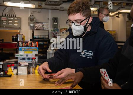 210214-N-RG587-1028 NORFOLK, VA (FEB 14, 2021) Cryptologic Technician (Maintenance) Petty Officer 3rd Class Jacob Masten, der dem Ticonderoga-Klasse Lenkraketen-Kreuzer USS Vella Gulf (CG 72) zugewiesen wurde, gibt Karten am 14. Februar 2021 aus. Vella Gulf ist die Pier-Seite der Norfolk Naval Station, die Routinewartung durchführt. Stockfoto