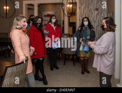 Theresa Nedrow, rechts, Interimsmanagerin des Alaska Fisher House, unterstellt Cindy Wilsbach, links, Ehefrau des Kommandanten der Pacific Air Forces, und andere Ehepartner von PACAF und der Joint Base Elmendorf-Richardson, Senior Leaders, während eines Besuchs im Fisher House II in JBER, Alaska, am 16. Februar 2021. Fisher House II wurde im September 2018 eröffnet und verfügt über 16 Suiten mit privaten Schlafzimmern und Bädern sowie eine gemeinsame Küche, ein Esszimmer, ein Wohnzimmer und eine Wäscherei. Fisher Houses bieten kostenlose Unterkunft für Familien von Patienten, die in großen medizinischen Zentren für Militär und Veterans Affairs betreut werden. Stockfoto