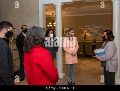 Theresa Nedrow, rechts, Interimsmanagerin des Alaska Fisher House, berichtet Cindy Wilsbach, zweite von rechts, Ehefrau des Kommandanten der Pacific Air Forces, und andere Ehepartner der PACAF und der Joint Base Elmendorf-Richardson, Senior Leaders, während eines Besuchs im Fisher House II in JBER, Alaska, am 16. Februar 2021. Fisher House II wurde im September 2018 eröffnet und verfügt über 16 Suiten mit privaten Schlafzimmern und Bädern sowie eine gemeinsame Küche, ein Esszimmer, ein Wohnzimmer und eine Wäscherei. Fisher Houses bieten kostenlose Unterkunft für Familien von Patienten, die in großen medizinischen Zentren für Militär und Veterans Affairs betreut werden. Stockfoto