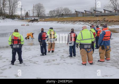 210216-N-EJ843-0004 GROTON, Conn. (Feb 16, 2021) Feuerwehrleute der Naval Submarine Base New London (SUBASE) Fire Department (SBFD) nehmen an einer Evolution der Kaltwasserrettung Teil. SBFD führt jährlich Übungen zur Rettung von kaltem Wasser durch, um ihr Wissen und ihre Techniken zu stärken. Stockfoto