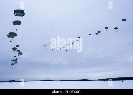 Fallschirmjäger mit dem Kampfteam der 4. Infanterie-Brigade (Airborne), 25. Infanterie-Division, führten im Rahmen von Arctic Warrior 21, 18. Februar, in der Malemute Drop Zone, Alaska, eine zweite Luftoperation durch. Die Fallschirmjäger des 1. Bataillons, des 501. Fallschirmjäger-Infanterie-Regiments und des 6. Brigade-Ingenieur-Bataillons (Airborne) sprangen zuvor in verschneiten Himmel und beendeten dann Ruck-Märsche, um ihre Fähigkeit zu bestätigen, luftgestützte Operationen unter arktischen Bedingungen durchzuführen. Die Spartan Brigade ist das einzige Luftgefechterteam der Infanteriebrigade im arktischen und pazifischen Raum, das das Kampfflugzeugkommando zur Verfügung stellt Stockfoto