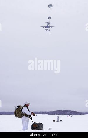 Fallschirmjäger mit dem Kampfteam der 4. Infanterie-Brigade (Airborne), 25. Infanterie-Division, führten im Rahmen von Arctic Warrior 21, 18. Februar, in der Malemute Drop Zone, Alaska, eine zweite Luftoperation durch. Die Fallschirmjäger des 1. Bataillons, des 501. Fallschirmjäger-Infanterie-Regiments und des 6. Brigade-Ingenieur-Bataillons (Airborne) sprangen zuvor in verschneiten Himmel und beendeten dann Ruck-Märsche, um ihre Fähigkeit zu bestätigen, luftgestützte Operationen unter arktischen Bedingungen durchzuführen. Die Spartan Brigade ist das einzige Luftgefechterteam der Infanteriebrigade im arktischen und pazifischen Raum, das das Kampfflugzeugkommando zur Verfügung stellt Stockfoto