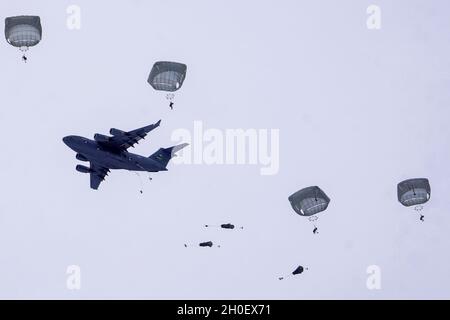 Fallschirmjäger mit dem Kampfteam der 4. Infanterie-Brigade (Airborne), 25. Infanterie-Division, führten im Rahmen von Arctic Warrior 21, 18. Februar, in der Malemute Drop Zone, Alaska, eine zweite Luftoperation durch. Die Fallschirmjäger des 1. Bataillons, des 501. Fallschirmjäger-Infanterie-Regiments und des 6. Brigade-Ingenieur-Bataillons (Airborne) sprangen zuvor in verschneiten Himmel und beendeten dann Ruck-Märsche, um ihre Fähigkeit zu bestätigen, luftgestützte Operationen unter arktischen Bedingungen durchzuführen. Die Spartan Brigade ist das einzige Luftgefechterteam der Infanteriebrigade im arktischen und pazifischen Raum, das das Kampfflugzeugkommando zur Verfügung stellt Stockfoto