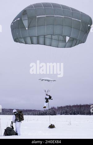 Fallschirmjäger mit dem Kampfteam der 4. Infanterie-Brigade (Airborne), 25. Infanterie-Division, führten im Rahmen von Arctic Warrior 21, 18. Februar, in der Malemute Drop Zone, Alaska, eine zweite Luftoperation durch. Die Fallschirmjäger des 1. Bataillons, des 501. Fallschirmjäger-Infanterie-Regiments und des 6. Brigade-Ingenieur-Bataillons (Airborne) sprangen zuvor in verschneiten Himmel und beendeten dann Ruck-Märsche, um ihre Fähigkeit zu bestätigen, luftgestützte Operationen unter arktischen Bedingungen durchzuführen. Die Spartan Brigade ist das einzige Luftgefechterteam der Infanteriebrigade im arktischen und pazifischen Raum, das das Kampfflugzeugkommando zur Verfügung stellt Stockfoto